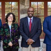 Four award recipients pose together outside of Alumni House